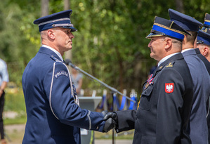 Komendant Wojewódzki Policji w Łodzi podaje rękę strażakowi.