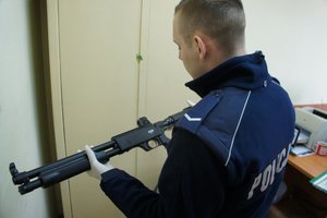 policjant podczas oględzin zabezpieczonych przedmiotów
