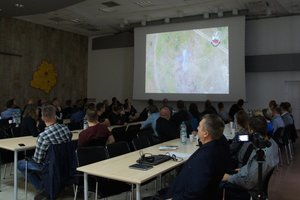 Sala konferencyjna goście i kierownictwo policji oraz słuchacze za stołem.