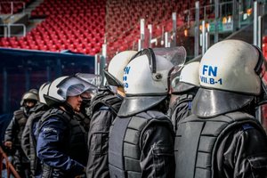 Policjanci stoją przy stadionie.