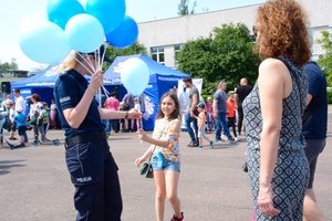 Policjanta rozdaje dzieciom balony.