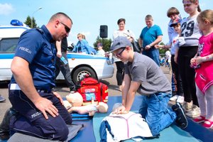 policjant uczy pierwszej pomocy chłopca