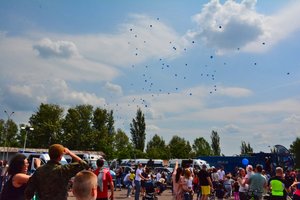 w niebo szybuje 100 niebieskich balonów wypuszczonych przez dzieci