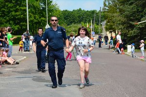 policjant pomaga dobiec do mety dziewczynce która wzięła udział w kids run