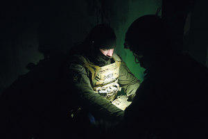 Policyjni medycy czekają w ciemnym pomieszczeniu.