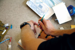 Ratownik na specjalnym manekinie ćwiczy nacinanie tchawicy.