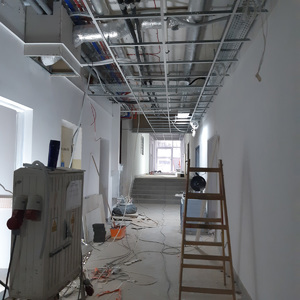 Konstrukcja kratownicowa podwieszanego sufitu w korytarzu budynku.