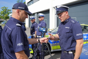 Zdjęcie przedstawia przedstawicieli Policji odbierających oficjalnie kluczyki do pięciu najnowszych radiowozów BMW M340i xDrive.