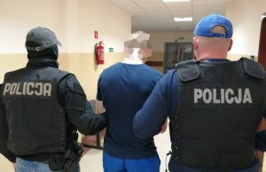 Jeden z zatrzymanych mężczyzn w asyście policjantów