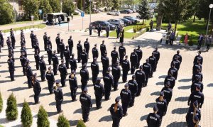 Umundurowani policjanci stojący w kilku szeregach. Zdjęcie z &quot;lotu ptaka&quot;