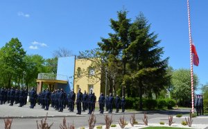 Umundurowani policjanci stojący w kilku szeregach.