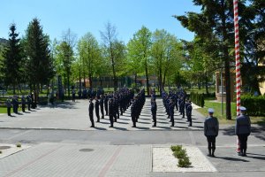 Umundurowani policjanci stojący w kilku szeregach. Zdjęcie z &quot;lotu ptaka&quot;