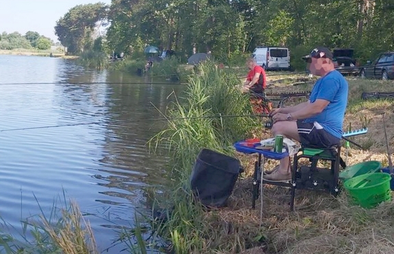 Mężczyźni z wędkami siedzący nad stawem