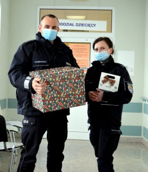 Umundurowana policjantka i policjant trzymają pudełko prezentowe