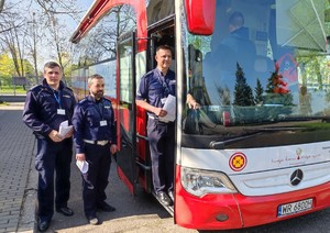 Umundurowani policjanci stojący w kolejce do oddawania krwi