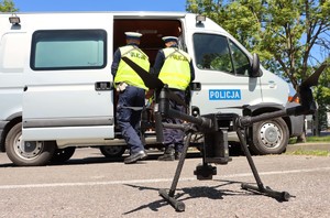 Dron oraz policjanci stojący w tle