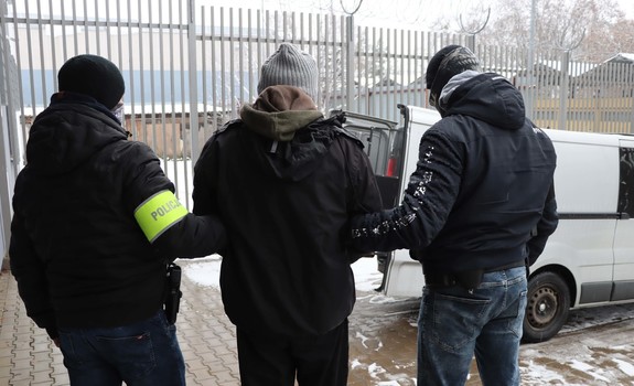 Zatrzymany mężczyzna prowadzony przez policjantów