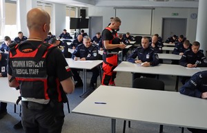 Umundurowani policjanci w sali wykładowej
