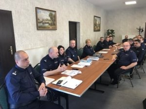 Umundurowani policjanci siedzący za stołem