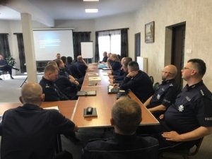 Umundurowani policjanci siedzący za stołem