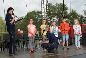 Umundurowana policjantka stojąca na scenie w dziećmi