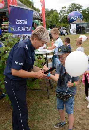 Umundurowana policjantka stojąca obok dziecka
