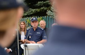 Umundurowany policjant stojący za mównicą