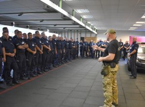 Umundurowani policjanci stojący na strzelnicy