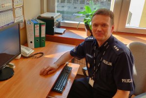 Umundurowany policjant siedzący przy biurku