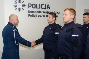 Umundurowani policjanci stojący w szeregu