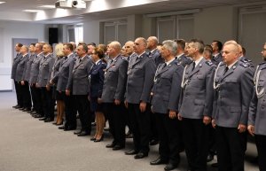 Umundurowani policjanci stojący na sali konferencyjnej