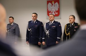 Umundurowani policjanci stojący na sali konferencyjnej