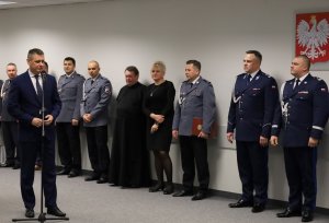 Umundurowani policjanci stojący na sali konferencyjnej