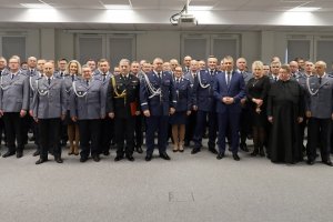 Umundurowani policjanci stojący na sali konferencyjnej