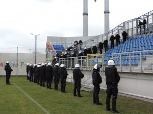 Umundurowani policjanci ćwiczący na stadionie piłkarskim
