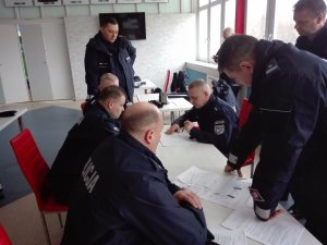 Umundurowani policjanci ćwiczący na stadionie piłkarskim