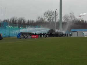 Umundurowani policjanci ćwiczący na stadionie piłkarskim