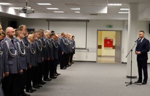 Umundurowani policjanci stojący w szeregu w sali