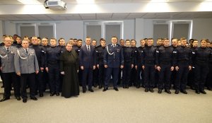 Umundurowani policjanci stojący w szeregu w sali