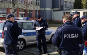 Policjanci stojący przed radiowozem