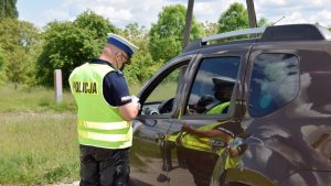 Policjanci kontrolujący samochody na drodze