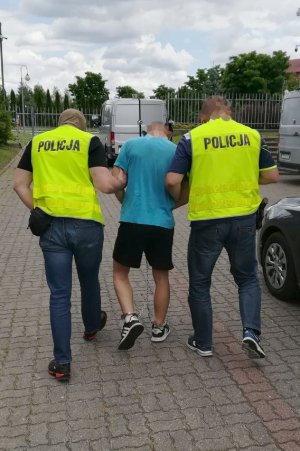 Policjanci prowadzą zatrzymanego