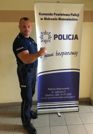 Umundurowany policjant stojący na korytarzu