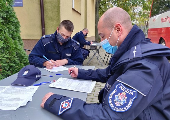 Policjanci siedzący przy stołach