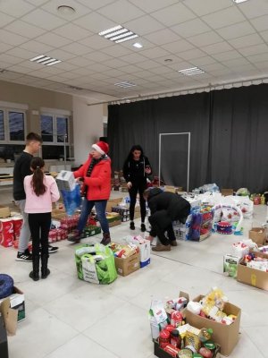 Osoby pakujące prezenty na sali gimnastycznej