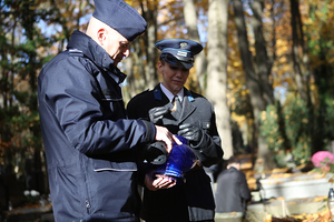 policjanci zapalają znicz