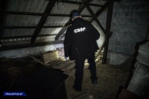 policjanci CBŚP w trakcie realizacji i zabezpieczona broń