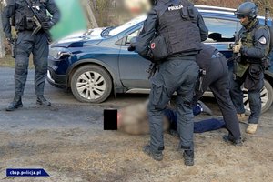 policjanci CBŚP w trakcie realizacji i zabezpieczona broń