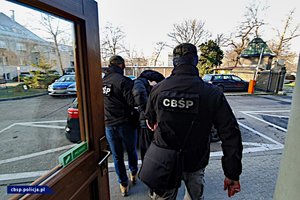 policjanci CBŚP i ujawnione substancje w beczkach oraz osoby zatrzymane