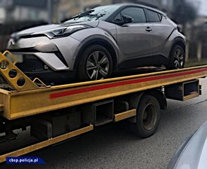 policjanci CBŚP i zabezpieczone samochody